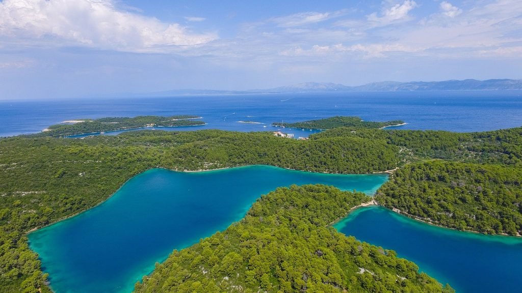 Le Parc national de Mljet est une véritable merveille naturelle située sur l'île de Mljet, en Croatie. Il s'étend sur plus de la moitié de l'île, offrant ainsi une abondance de paysages époustouflants et de richesses naturelles. Ce parc est un véritable paradis pour les amoureux de la nature et les adeptes des activités en plein air.

L'un des joyaux du parc est le lac salé de Mljet, un véritable trésor cristallin. Avec ses eaux turquoise et ses rives verdoyantes, le lac offre une expérience de baignade unique. Vous pourrez vous détendre dans ses eaux salées, réputées pour leurs bienfaits sur la peau et la santé.

Au cœur du lac se trouve l'îlot de Sainte-Marie, où se dresse le magnifique monastère de Sainte-Marie. Ce monastère datant du XIIe siècle est un véritable chef-d'œuvre architectural et historique. En y accédant par bateau-taxi, vous pourrez explorer ses murs anciens et découvrir son riche patrimoine culturel.

Le Parc national de Mljet regorge également de sentiers de randonnée pittoresques, parfaits pour les amateurs de promenades en pleine nature. Les sentiers serpentent à travers les forêts denses, les collines verdoyantes et les vallées tranquilles, offrant des vues panoramiques à couper le souffle.

En plus de sa beauté naturelle, le parc abrite une biodiversité exceptionnelle, avec une flore et une faune uniques. Vous pourrez y observer des espèces d'oiseaux rares, des orchidées sauvages et bien d'autres trésors de la nature.

En visitant le Parc national de Mljet, vous serez immergé dans un monde de tranquillité, de beauté et d'aventure. C'est une destination incontournable pour les amoureux de la nature et les voyageurs en quête d'expériences authentiques.